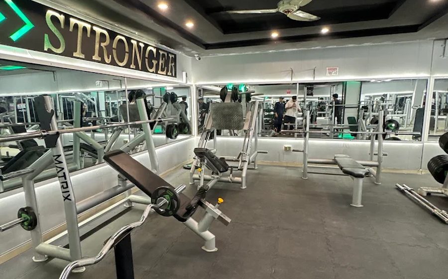 Free-weight and bench area beneath the Stronger signage